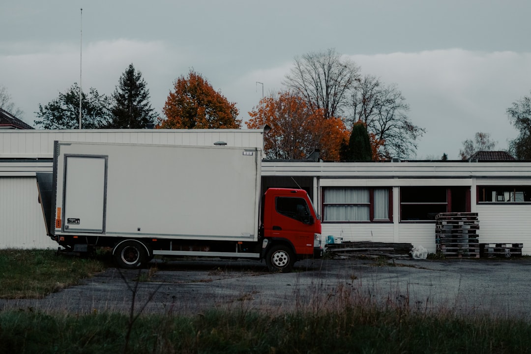 Red truck parked next to a white building.
