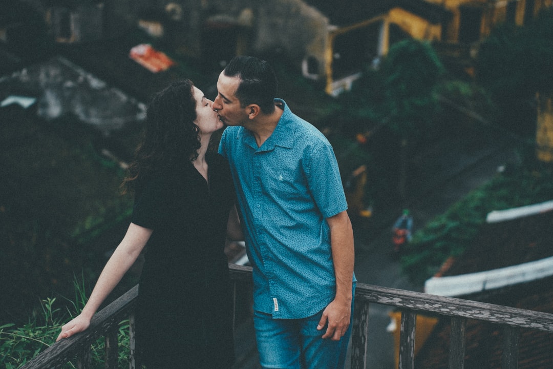 Couple kissing on a balcony overlooking rooftops