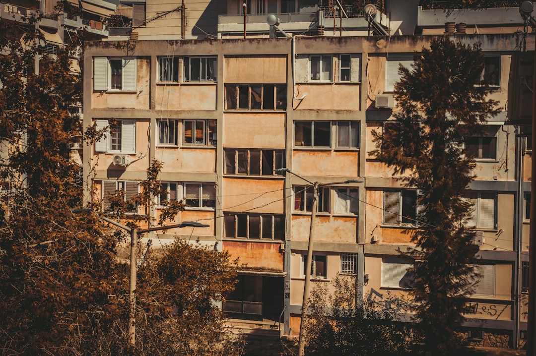Apartment building facade framed by trees.