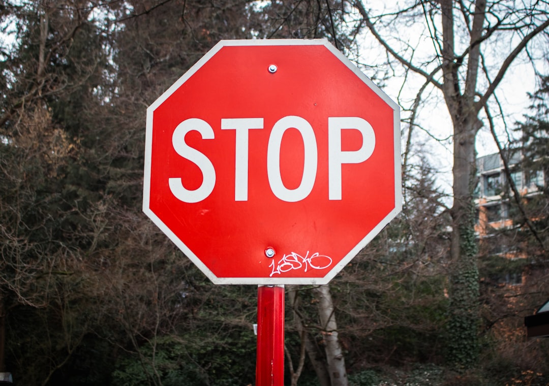 A stop sign is visible in front of trees.