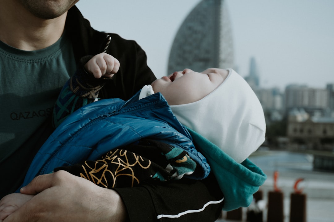 Man holding a baby with city skyline background