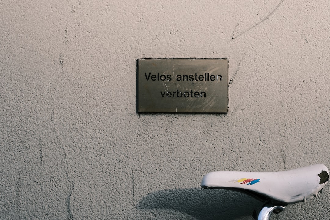 a bicycle parked next to a wall with a sign on it