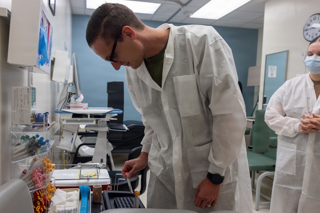 Scientist in lab coat examines sample in laboratory.
